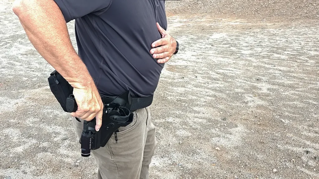 Rack the slide by safely and firmly running it against the edge of your holster.